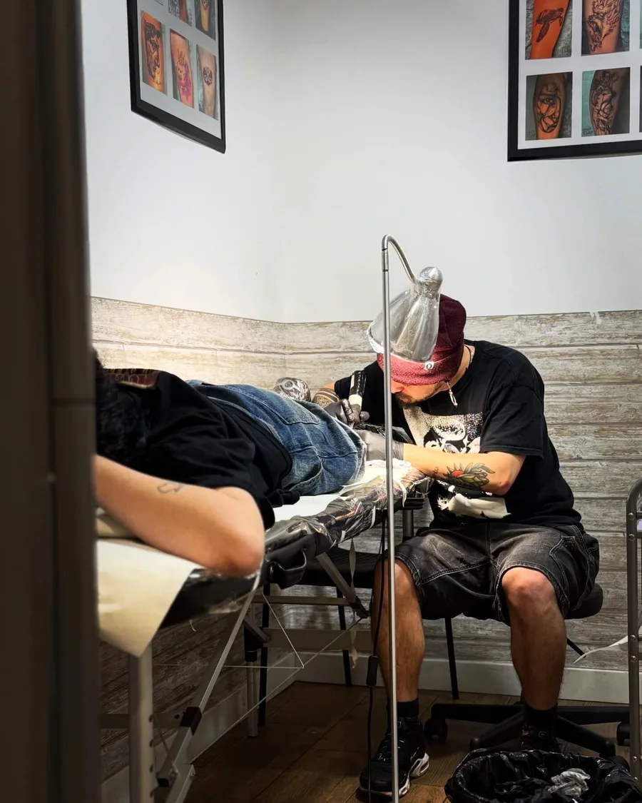 Alumno tatuando a un modelo en una cabina de la escuela ESAP de Madrid