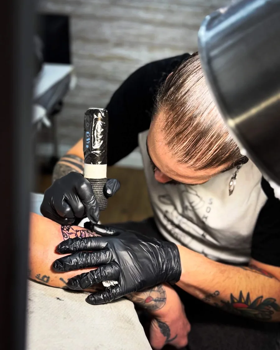 Alumna tatuando la nuca de una persona en las prácticas de la escuela ESAP de Madrid