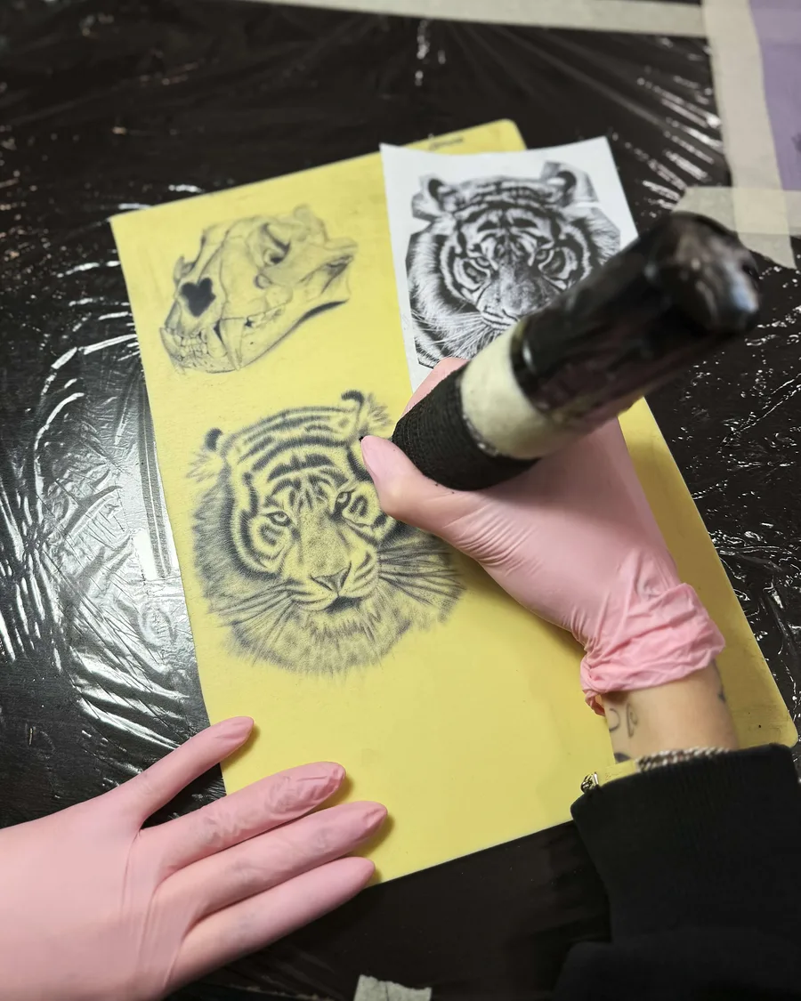 Alumno tatuando un tigre sobre piel sintética en la escuela ESAP de Madrid