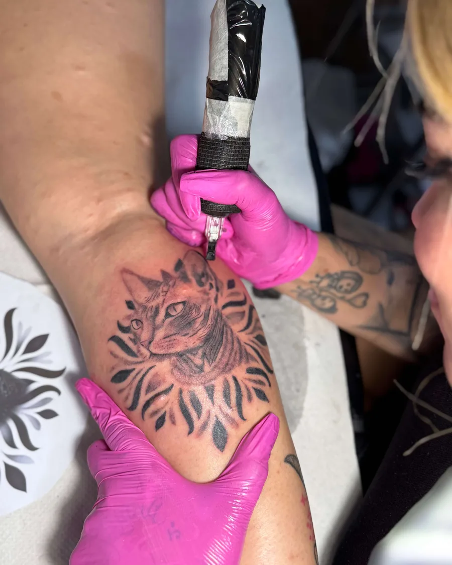 Alumna tatuando un felino en una pierna en la escuela ESAP de Madrid Alumna tatuando un felino en una pierna en la escuela ESAP de Madrid