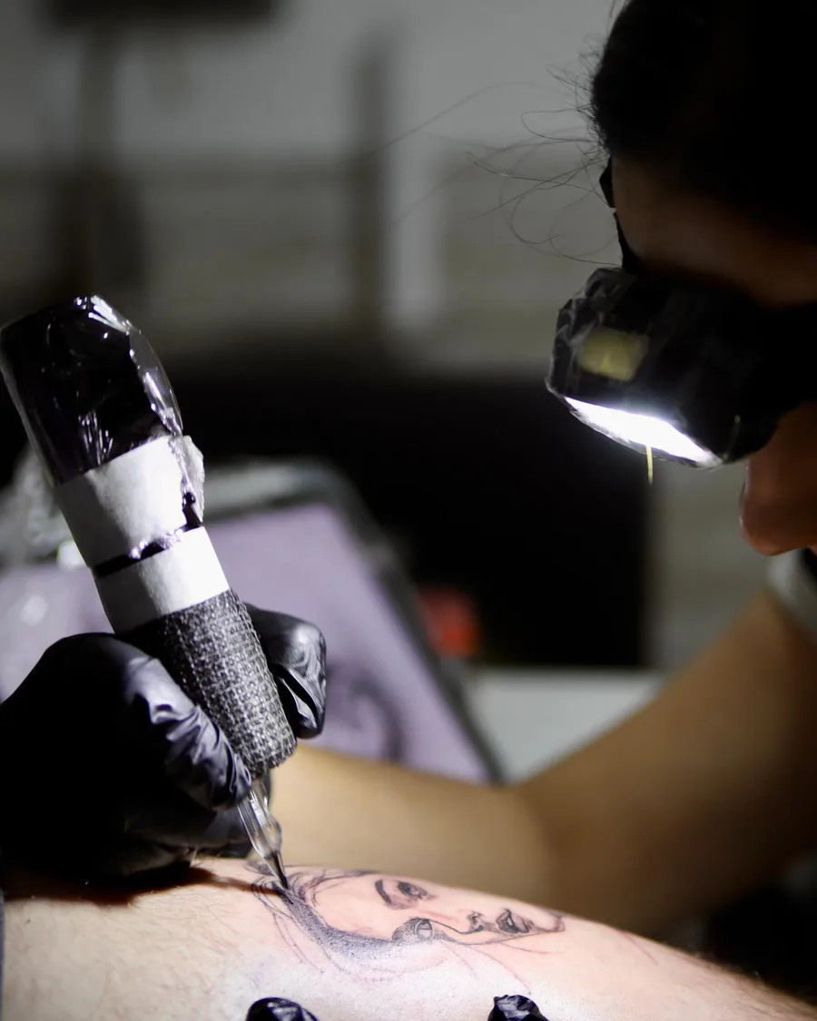 Alumno practicando el tatuaje sobre piel sintética con la máquina en la escuela ESAP de Madrid