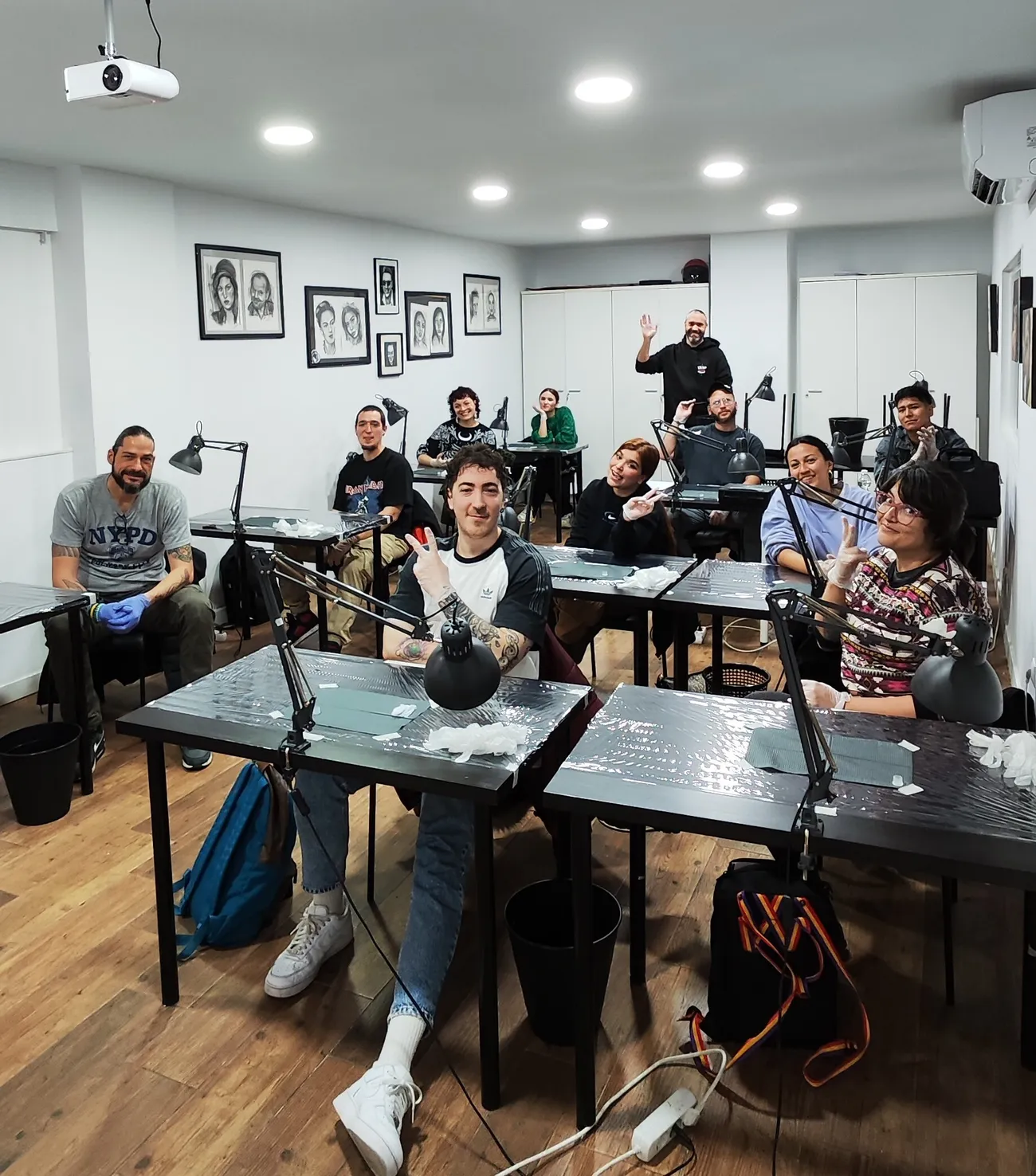 Alumnos en clase en ESAP Madrid Alumnos practicando en clase en la escuela de tatuaje ESAP de Madrid